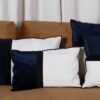 Housse de coussin Dark navy en velours et coton recyclé sur un canapé moderne.