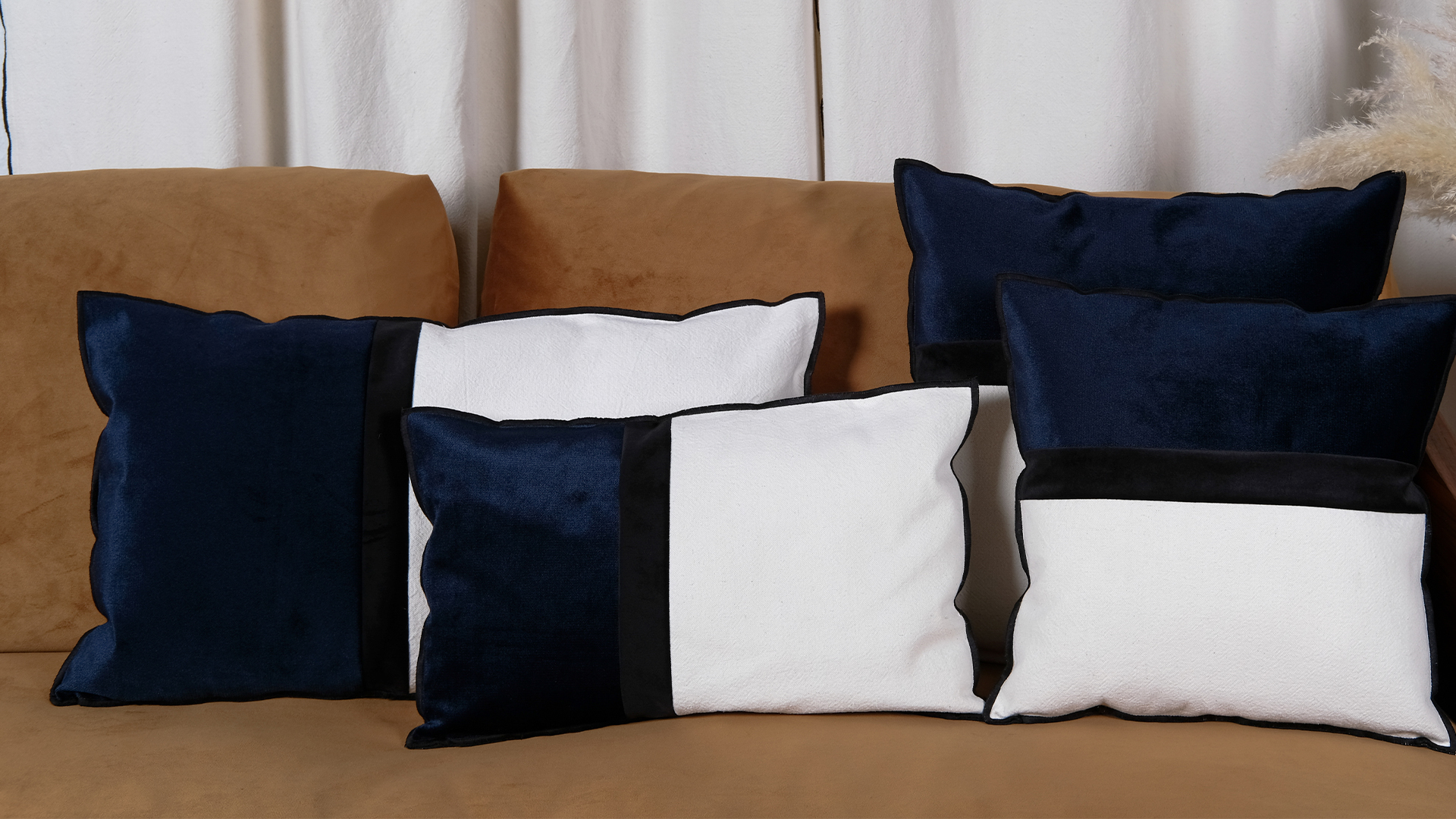 Housse de coussin Dark navy en velours et coton recyclé sur un canapé moderne.